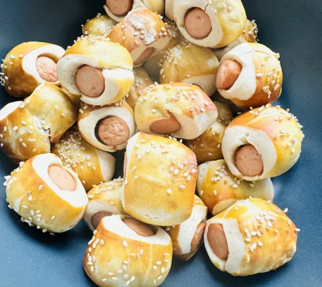 Leckere Würstchen im Teigmantel, bestreut mit Sesam. Perfekt als Fingerfood für eine Babyparty, diese Rezepte sind ein Hit!