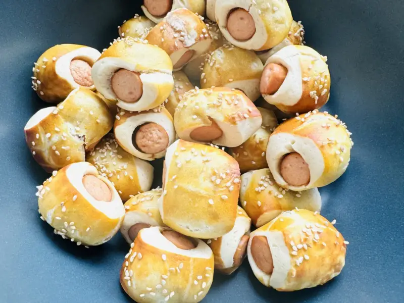 Leckere Würstchen im Teigmantel, bestreut mit Sesam. Perfekt als Fingerfood für eine Babyparty, diese Rezepte sind ein Hit!